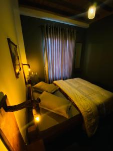 a dark room with two beds and a window at Rustique House dbl in Nuwara Eliya