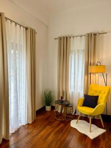 Sala de estar con silla amarilla y mesa en Mala Italia Apartments, en Wroclaw
