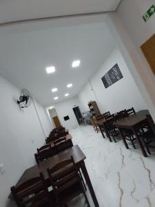 an empty room with wooden tables and chairs at Aparecida Akuto's Pousada in Aparecida