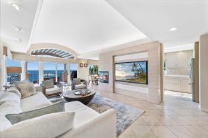 una sala de estar con muebles blancos y vistas al océano. en Laguna Villa en Laguna Beach