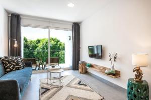 a living room with a blue couch and a large window at Casa Boaz in Carvoeiro