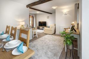 a living room and dining room with a table and chairs at Manor Farm Barn Cottage in Burton