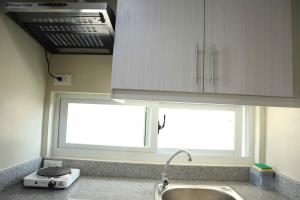 a kitchen counter with a sink and a window at Cute 23 sqm condo for the cuties near AYALA CEBU in Cebu City