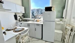 eine kleine Küche mit einem weißen Kühlschrank und einem Fenster in der Unterkunft Cozy one bedroom Limeapartment in Haifa