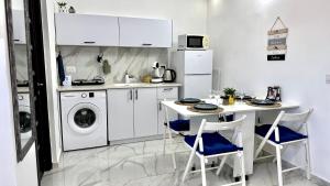 eine Küche mit einer Waschmaschine und einem Tisch mit Stühlen in der Unterkunft Cozy one bedroom Limeapartment in Haifa