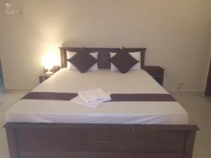 uma cama com lençóis e almofadas preto e branco em MercuryFM 103 Guest House - Colombo 3 em Colombo