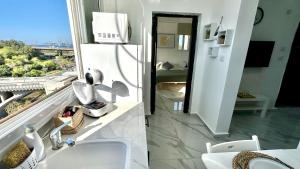ein Bad mit einem Waschbecken und Blick auf ein Zimmer in der Unterkunft Cozy one bedroom Limeapartment in Haifa