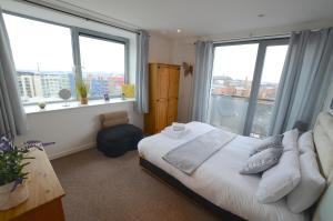 a bedroom with a bed and windows with a view at Cranbrook House Apartments - Near Ice Arena in Nottingham