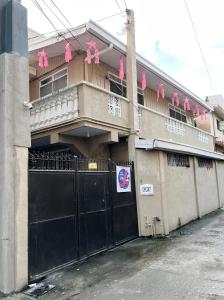 un edificio con una puerta negra y arcos rosados en 5J’s Space Rental, en Legazpi