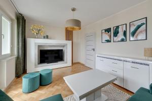a living room with a table and a fireplace at Platinium Apartament Morski in Gdańsk