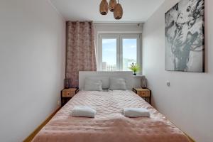 a bedroom with a large bed with a window at Platinium Apartament Morski in Gdańsk