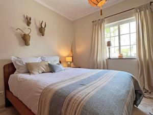 a bedroom with a large bed and a window at Casa Miobelle - Tavira in Tavira
