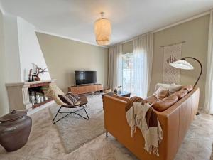 a living room with a couch and a chair at Casa Miobelle - Tavira in Tavira