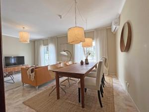 a dining room and living room with a table and chairs at Casa Miobelle - Tavira in Tavira