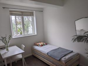 a small bedroom with a bed and a window at Creatives' House in London