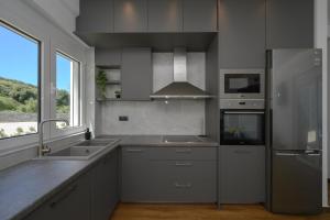 uma cozinha com electrodomésticos de aço inoxidável e uma grande janela em Kalostous em Agia Triada