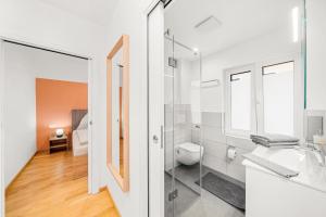 a white bathroom with a sink and a toilet at Hallstatt Lakeside Top 6 - Zimmer mit Balkon in Hallstatt