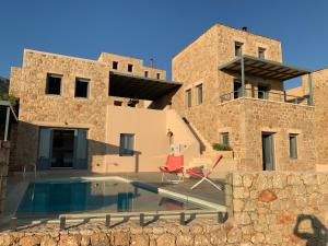 a villa with a swimming pool in front of a building at Patio Villa Lydia in Stoupa