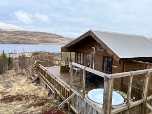 ein großes Holzhaus mit einer Badewanne auf der Terrasse in der Unterkunft Icelandic Lake House in Akranes