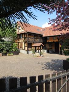 un gran edificio de madera con techo rojo en Gîte Le Vigneron, en Donnenheim