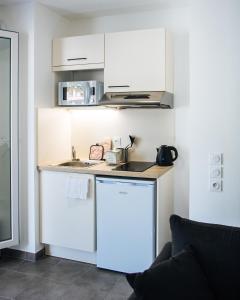 una pequeña cocina con fregadero y nevera. en Twenty Business Flats Nice Angely en Niza