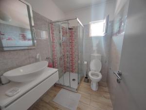 Family Deluxe Apartment Mirjana في Kampor: حمام مع حوض ومرحاض ودش