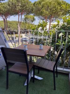 a wooden table and a bench on a balcony at Studio 4 pers, au calme, parking privé, wifi, linges fournis, 2 étoiles de France in La Grande Motte