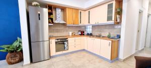 a kitchen with white cabinets and a stainless steel refrigerator at Blue Siri Apartment in Heraklio