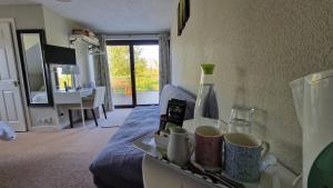 een kamer met een bed en een dienblad met kopjes bij Golden Hill Guest House in Omagh