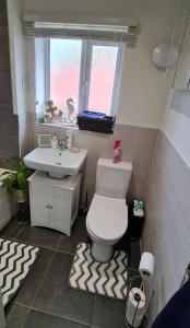 a bathroom with a toilet and a sink and a window at Magnolia House in Nantwich