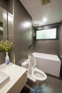 uma casa de banho com um WC, um lavatório e uma banheira em J'ADORE APARTMENT em Hanói
