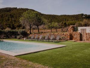 - un groupe de chaises assises à côté de la piscine dans l'établissement Cas Orvais con piscina y jardín, à Sant Jordi