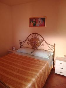 1 dormitorio con 1 cama y una foto en la pared en Oasi Sicula Apartment, en Petrosino