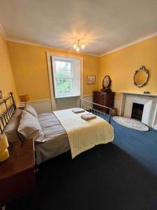 a bedroom with a bed and a window and a fireplace at Powis House Mid Cottage in Stirling