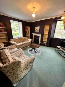 a living room with two couches and a coffee table at Powis House Mid Cottage in Stirling