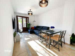 uma sala de estar com um sofá azul e uma mesa em PET001 - Modern 2 Bedroom Apartment em Ayamonte