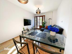 uma sala de estar com uma mesa de vidro e um sofá em PET001 - Modern 2 Bedroom Apartment em Ayamonte