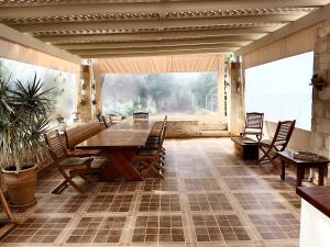 um quarto amplo com uma mesa de madeira e cadeiras em Korfe Estate em Fodele