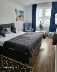 een slaapkamer met een groot bed en een stoel bij David’s place in Floreşti