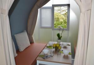 eine kleine Küche mit einem Tisch und einem Fenster in der Unterkunft Camping la Chaumière in Heimsbrunn