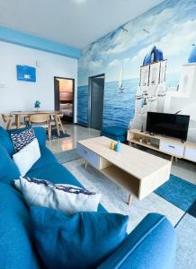 Seaview Homestay Masai by Heyday في ماساي: غرفة معيشة مع أريكة زرقاء وتلفزيون