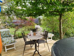 une terrasse avec 4 chaises, une table et un arbre dans l'établissement chambres d'hôtes naturistes de la moque souris, à Saint-Pierre-de-Mailloc