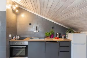 een keuken met witte apparatuur en een houten plafond bij Apartment Tete Mare in Dubrovnik