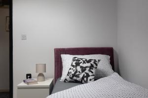 een bed met een zwart-wit kussen en een nachtkastje bij Apartment Tete Mare in Dubrovnik