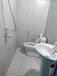bagno con servizi igienici e lavandino di faTuur Inn a Città di Malé