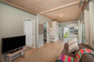 un soggiorno con divano e TV a schermo piatto di Kōpuha on Rangiora - Matarangi Holiday Home a Matarangi