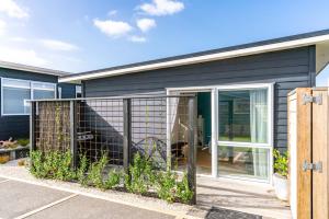 een hond zit in een huis bij Marram Studio - Mangawhai Holiday Studio in Mangawhai