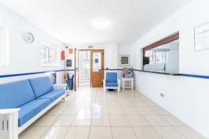 Apartamentos Isla de Lobos - Adults Only في بويرتو ديل كارمن: غرفة معيشة مع أريكة زرقاء وطاولة
