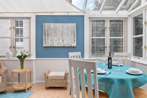 a dining room with a blue table and chairs at Cockington Cottages in Torquay