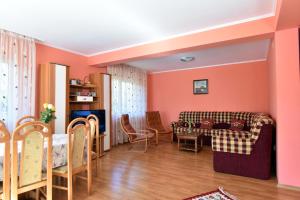 a living room with pink walls and a couch and chairs at Vila Roberta in Buşteni